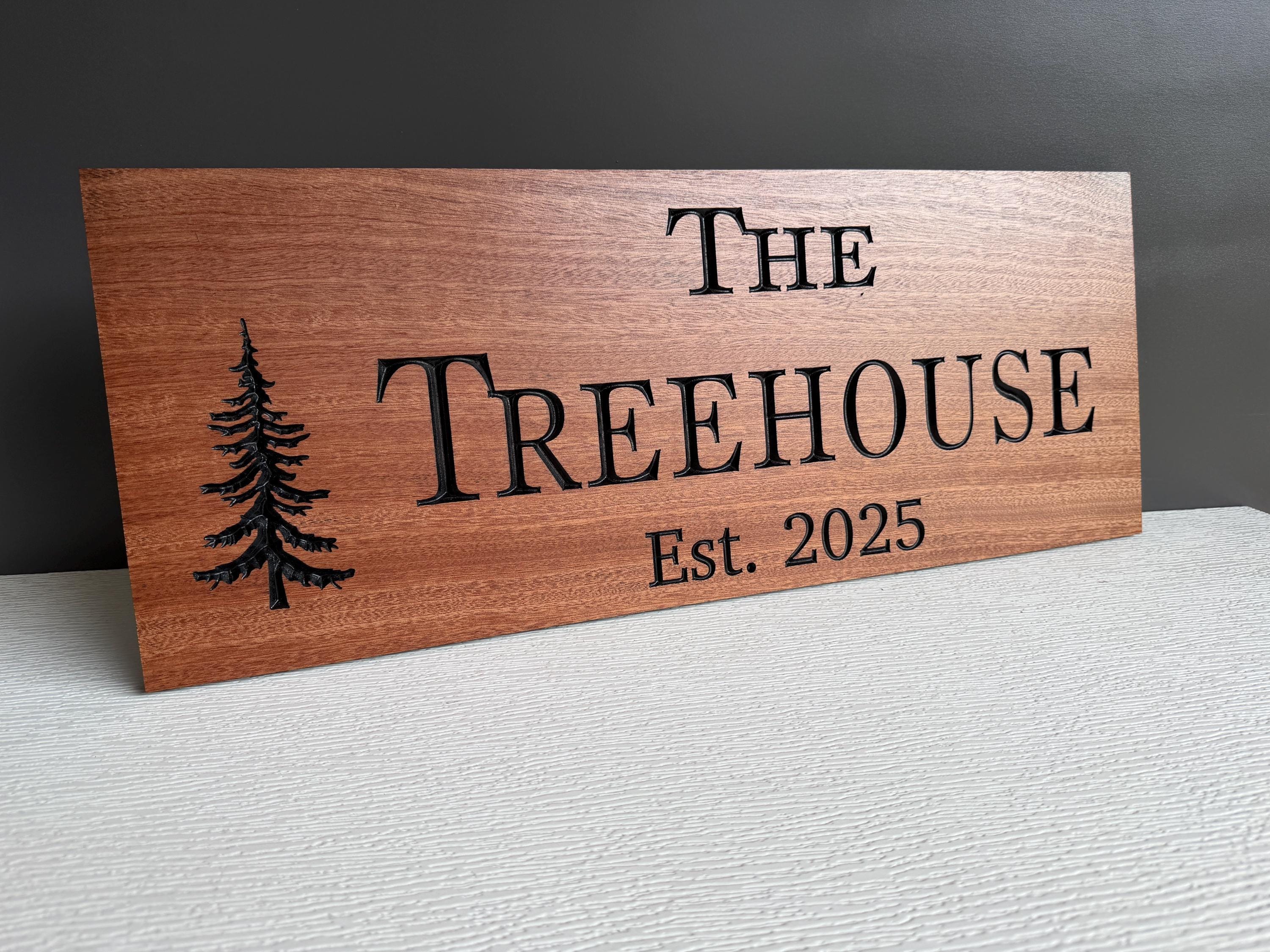 A wooden sign with the name "The Treehouse" and the year "Est. 2025" printed on it.