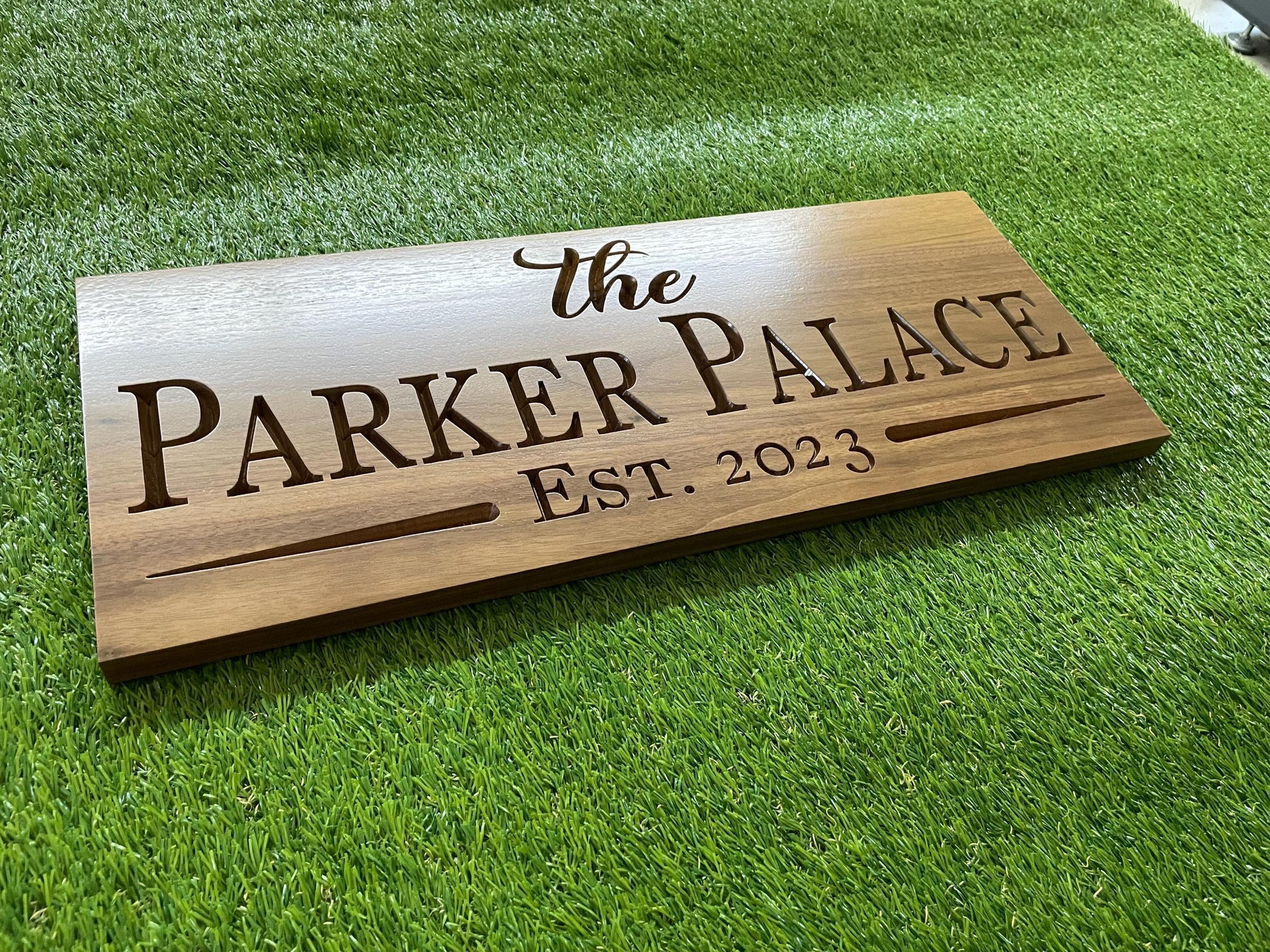 a wooden sign sitting on top of a lush green field