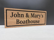 A wooden sign with the text "John & Mary's Boathouse" on it.