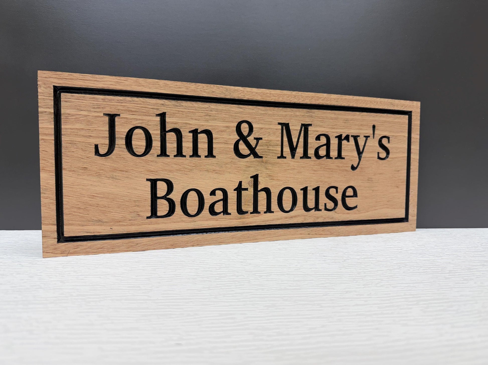 A wooden sign with the text "John & Mary's Boathouse" on it.
