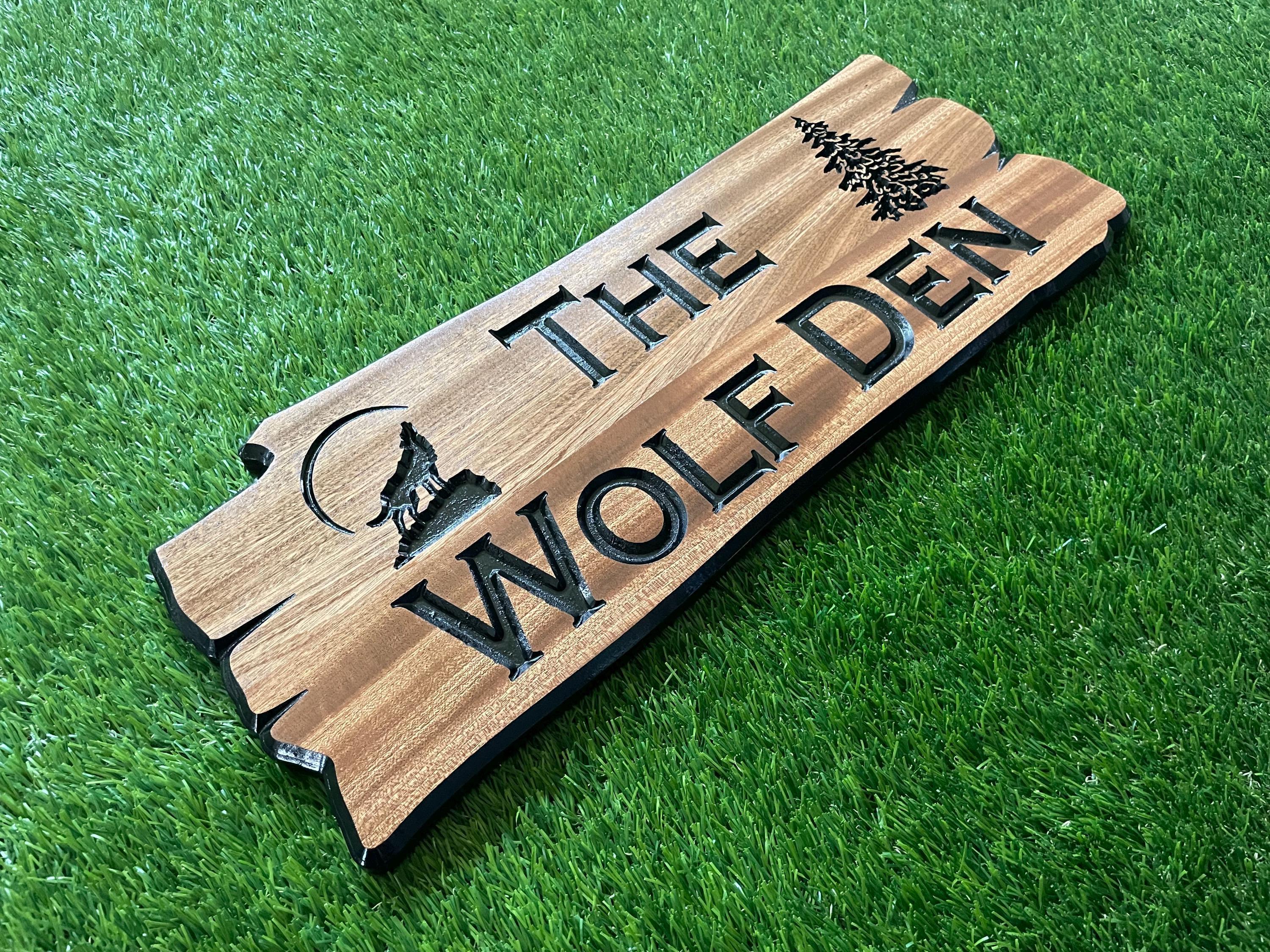 a wooden sign sitting on top of a lush green field