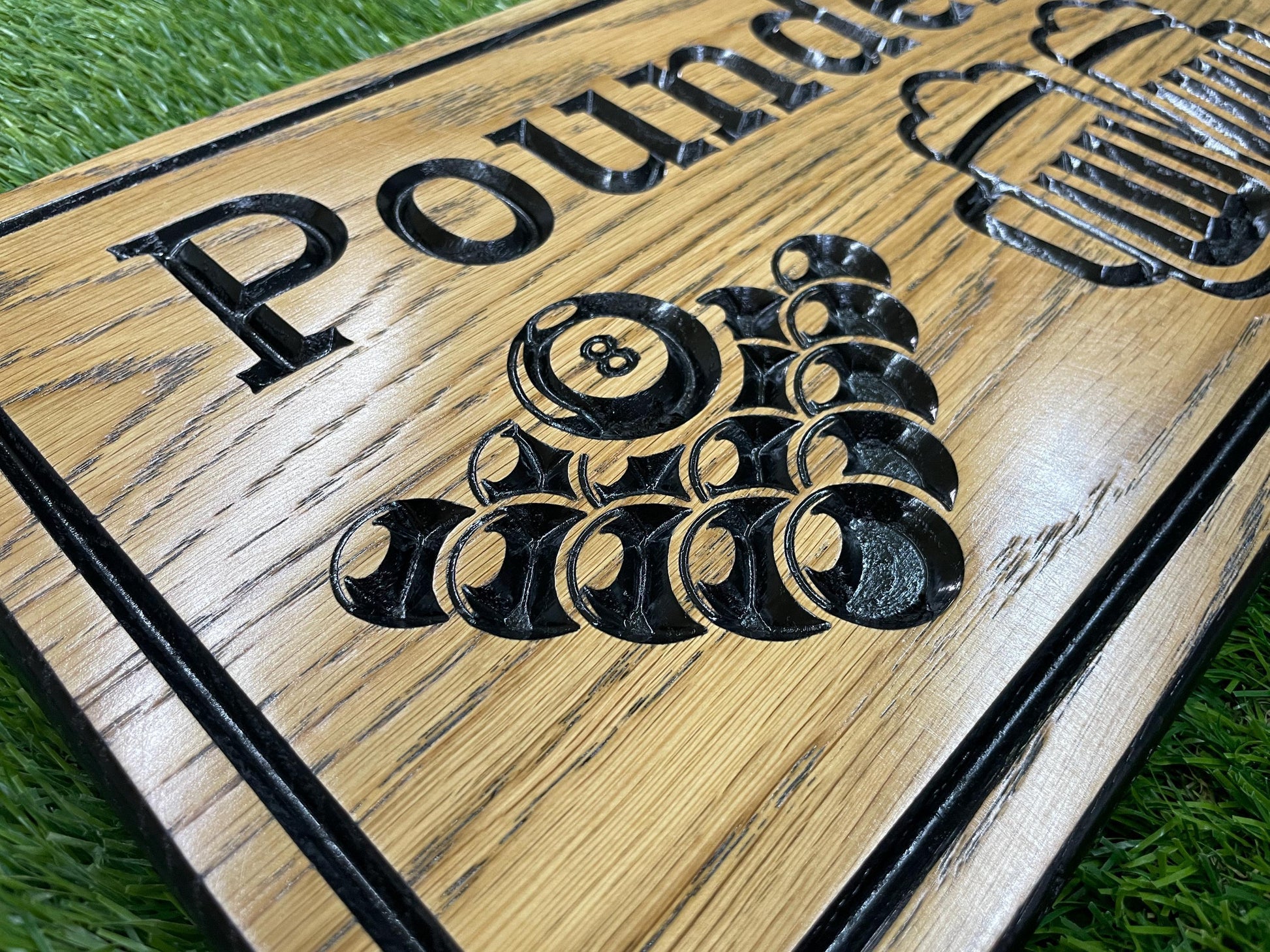 a close up of a wooden sign on the grass