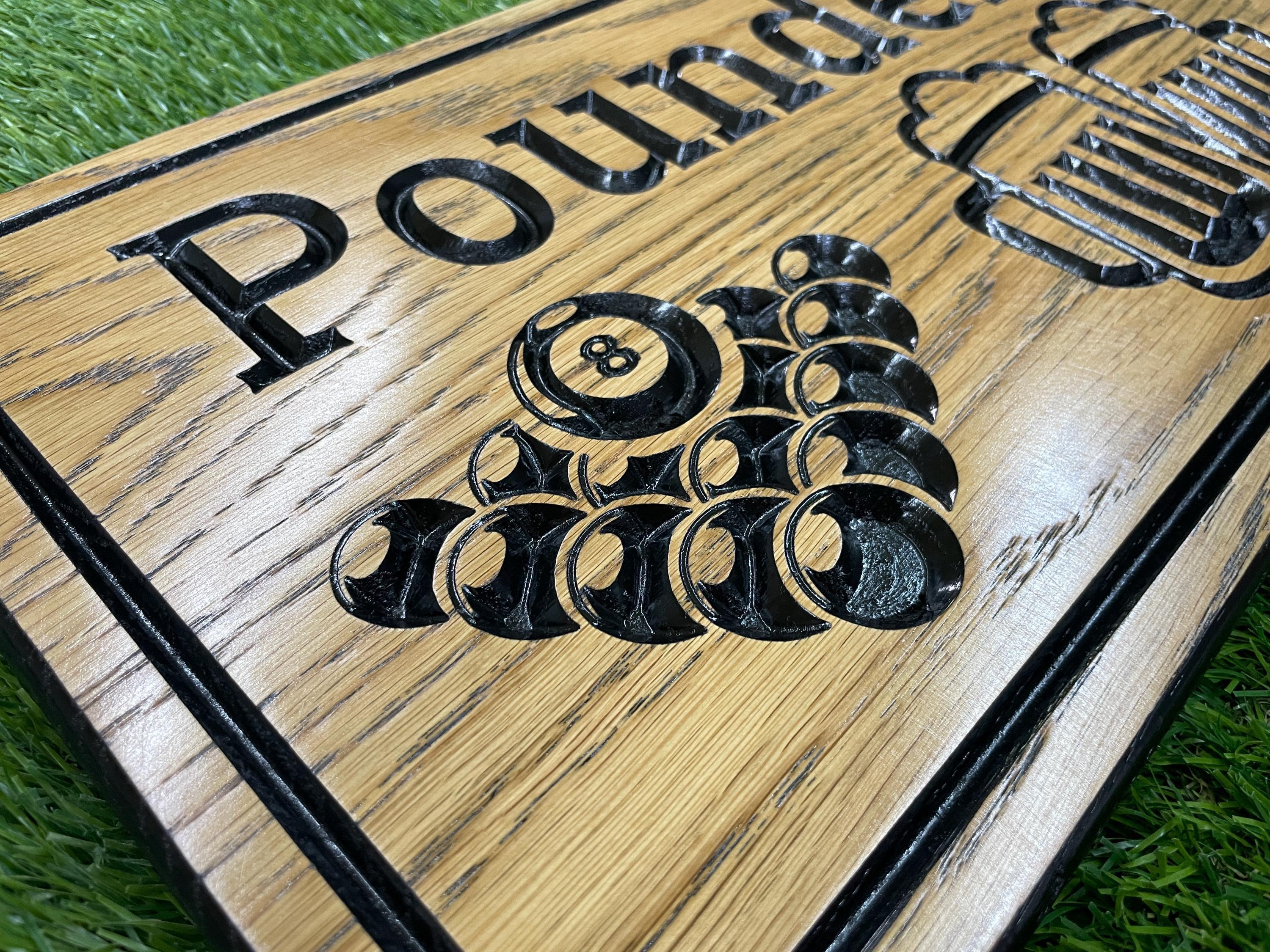 a close up of a wooden sign on the grass