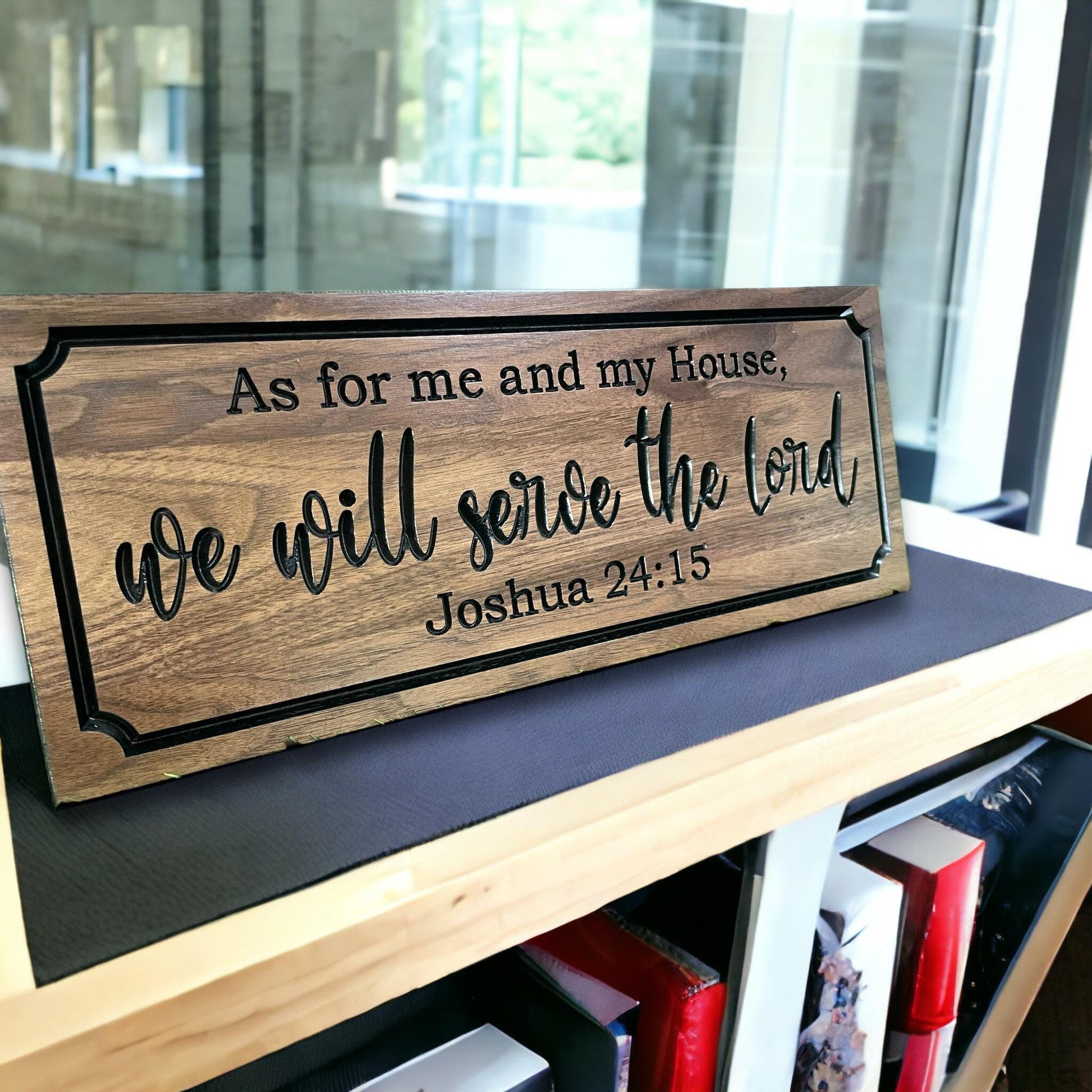 A wooden sign with the text "As for me and my House, we will serve the Lord Joshua 24:15" displayed on a shelf.