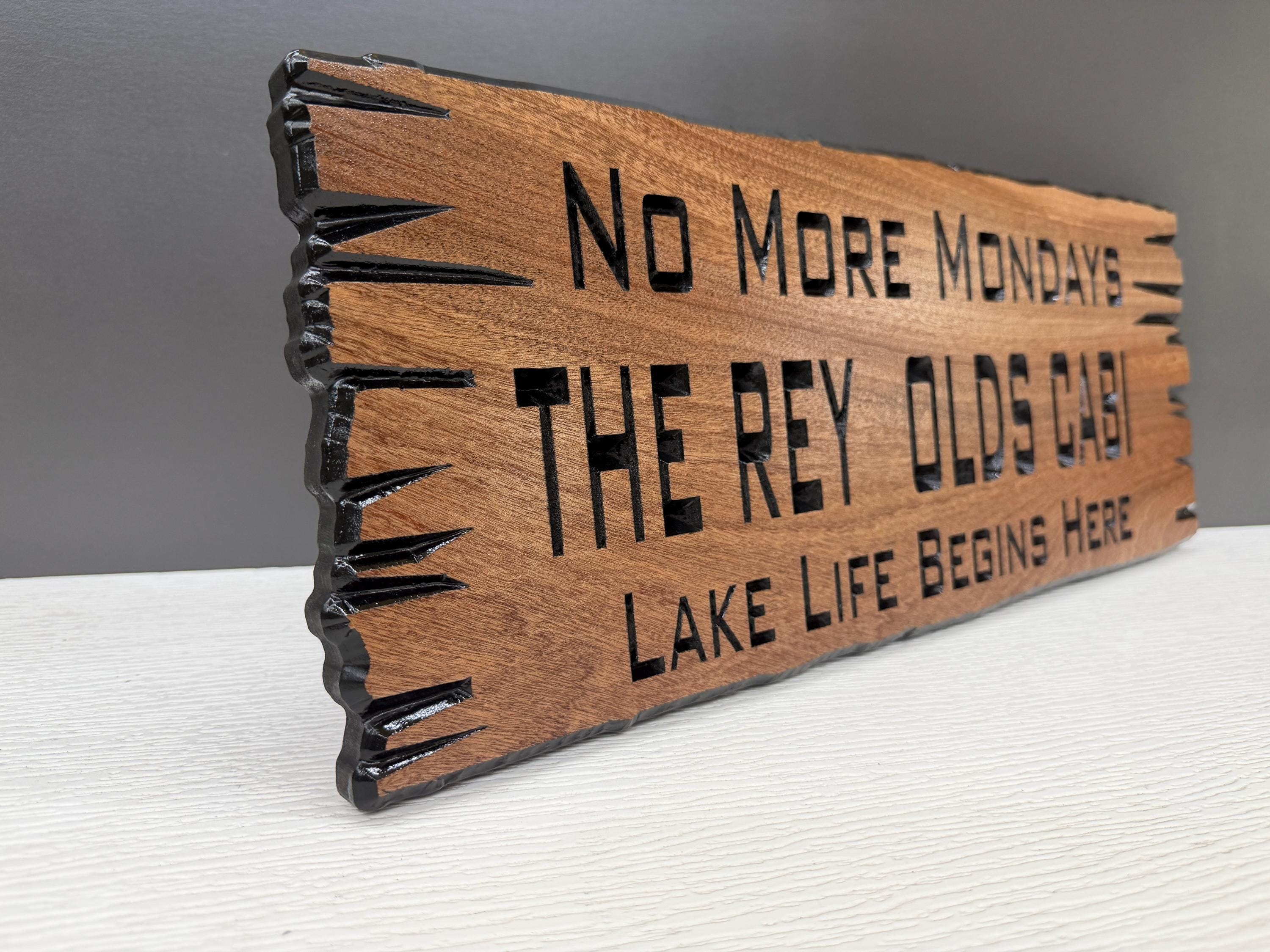 A wooden sign with the text "No More Mondays" and "The Rey Olds Cab" carved into it.