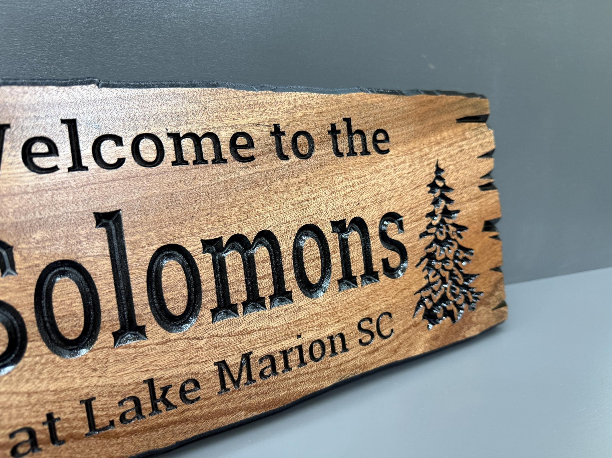 A wooden sign with the text "Welcome to the Solomons at Lake Marion SC" carved into it.