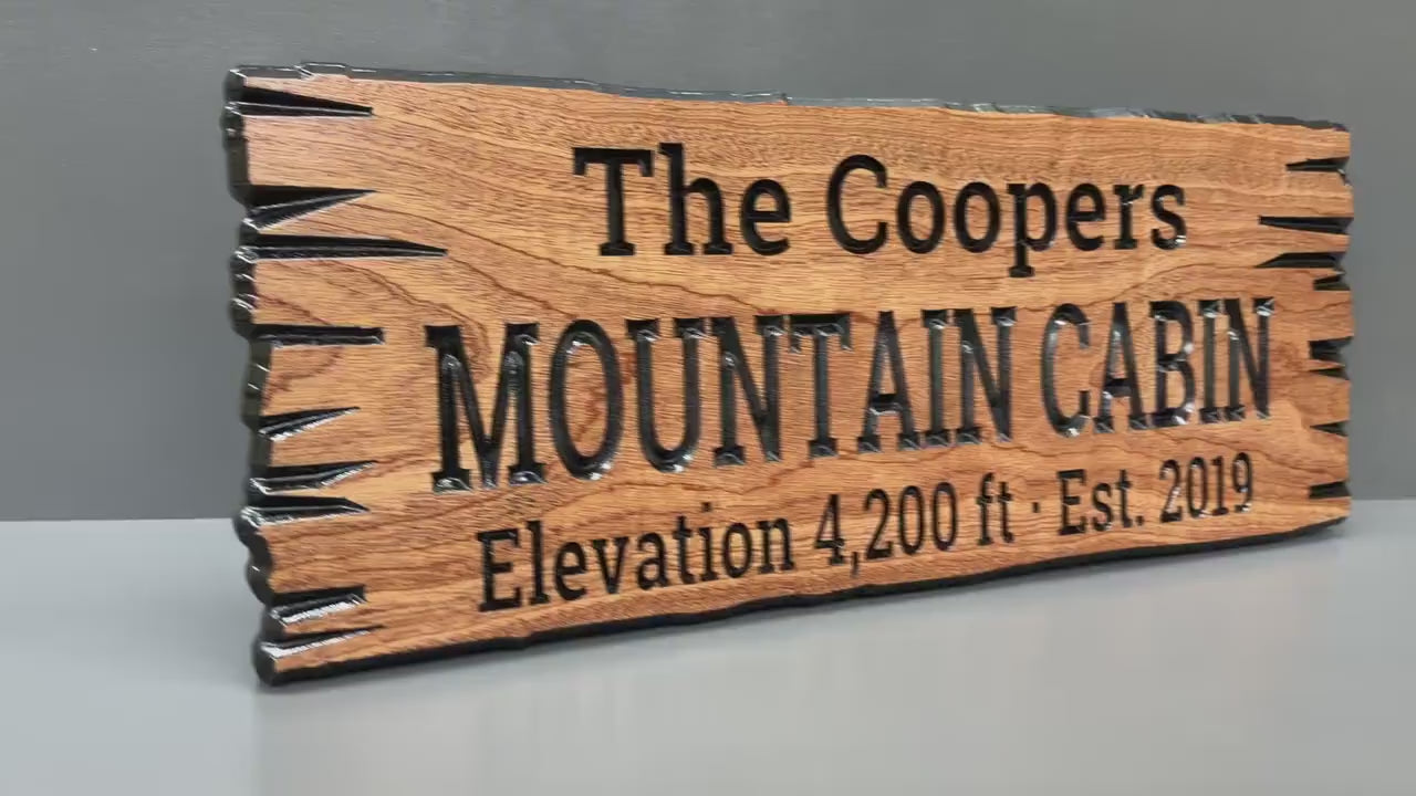 Load video: Mountain Cabin Sign Custom Wood Live Edge, Personalized Mountain Home Sign Carved Hardwood, Family Name Mountain Sign Cabin